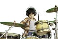 A cute Asian boy is enjoying playing the drums in a music classroom. Royalty Free Stock Photo