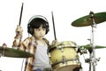 A cute Asian boy is enjoying playing the drums in a music classroom.