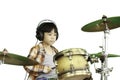 A cute Asian boy is enjoying playing the drums in a music classroom. Royalty Free Stock Photo