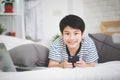 Cute asian boy rest on bed and using smart cell phone with smile Royalty Free Stock Photo