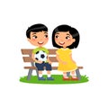 Cute asian boys with soccer ball and little asian girl sit on bench.