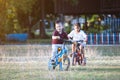 Asian child boy and his old sister having fun to ride a bicycle together in the park Royalty Free Stock Photo