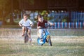 Asian child boy and his old sister having fun to ride a bicycle together in the park Royalty Free Stock Photo