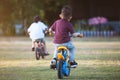 Asian child boy and his old sister having fun to ride a bicycle together in the park Royalty Free Stock Photo