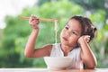 Cute asian child girl bored to eat Instant noodles