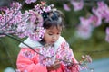 Cute asian child girl enjoying with beautiful pink cherry blossom garden Royalty Free Stock Photo