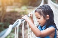 Cute asian child girl goes on the hanging rope bridge Royalty Free Stock Photo