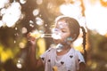 Cute asian child girl having fun to blow soap bubbles in outdoor Royalty Free Stock Photo