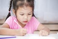 Cute asian child girl having fun to draw and paint with crayon Royalty Free Stock Photo