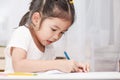 Cute asian child girl having fun to draw and paint with crayon Royalty Free Stock Photo