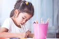 Cute asian child girl having fun to draw and paint with crayon Royalty Free Stock Photo