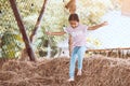 Cute asian child girl having fun to jump and play with hay stack Royalty Free Stock Photo