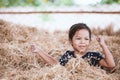 Cute asian child girl having fun to play with hay stack Royalty Free Stock Photo