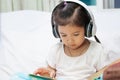 Cute asian child girl in headphones listening the music Royalty Free Stock Photo