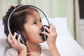 Cute asian child girl in headphones listening the music Royalty Free Stock Photo