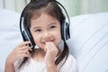 Cute asian child girl in headphones listening the music