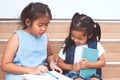 Cute asian child girl and her sister reading a book Royalty Free Stock Photo