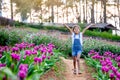 Cute asian child girl raise their arms and run in the flower garden Royalty Free Stock Photo