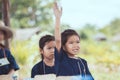 Cute asian child girl raising her hand in the air to answer Royalty Free Stock Photo