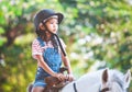 Cute asian child girl riding a horse in the farm Royalty Free Stock Photo