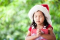 Cute asian child girl in santa red hat holding Christmas gift Royalty Free Stock Photo