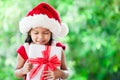 Cute asian child girl in santa red hat holding Christmas gift Royalty Free Stock Photo