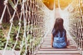 Cute asian child girl sitting on the hanging rope bridge Royalty Free Stock Photo