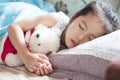 Cute asian child girl sleeping and hugging her teddy bear Royalty Free Stock Photo