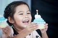 Cute asian child girl smiling and blow her birthday cupcake Royalty Free Stock Photo