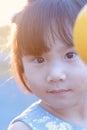 Cute Asian child girl is smiling happily in the park with sunset.