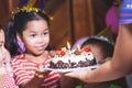 Cute asian child girl is surprising with delicious birthday cake which her mother give to her. Royalty Free Stock Photo