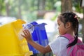 Cute asian child girl throwing plastic glass in recycling trash