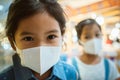 Cute asian child girl wearing protection mask to against air smog pollution with PM 2.5