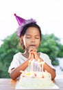 Asian child girls make folded hand to wish the good things for her birthday in birthday party Royalty Free Stock Photo