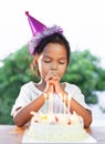 Asian child girls make folded hand to wish the good things for her birthday in birthday party Royalty Free Stock Photo