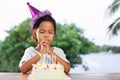 Asian child girls make folded hand to wish the good things for her birthday in birthday party Royalty Free Stock Photo