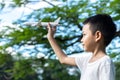 Cute Asian child playing airplane in the park outdoors Happy Asian boy holding a plane runs in a meadow with sunset Royalty Free Stock Photo