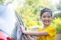 Cute asian child washing a car with hose on summer day Royalty Free Stock Photo