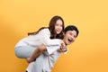 Cute Asian couple is proudly showing off their cheerful and happy expressions. He made the woman piggy-back ride
