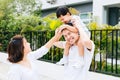 Cute Asian father piggbacking his son along with his wife in the park. Excited family spending time together with happiness. Royalty Free Stock Photo