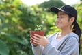 Cute girl closed eyes while holding a plant in her hands. Saving the world, earth day concept. Royalty Free Stock Photo