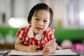 Cute Asian girl doing her homework. Royalty Free Stock Photo