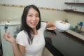 Cute Asian girl eating healthy - young beautiful and happy Japanese woman at home kitchen having lunch smiling cheerful holding Royalty Free Stock Photo