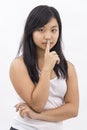 Cute serious asian girl on isolated background thinking making silence sign