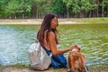 Cute asian girl with little dog walking in park. Woman sitting on green grass with dog - outdoor in nature portrait. Pet, domestic Royalty Free Stock Photo