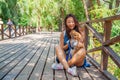 Cute asian girl with little dog walking in park. Woman sitting on green grass with dog - outdoor in nature portrait. Pet, domestic Royalty Free Stock Photo