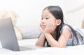 Cute asian girl looking computer on bed, Royalty Free Stock Photo
