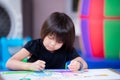 Cute Asian girl is making art drawing and painting a story about herself and her sister on paper. Royalty Free Stock Photo