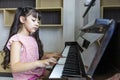Cute Asian girl is practicing her classical piano lesson at home for song writing and music education concept Royalty Free Stock Photo