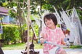 Cute Asian girl riding bicycle. Sweet smile child looking at camera. Happy kid wearing pink clothes. Active children exercising. Royalty Free Stock Photo